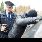 police-arresting-a-criminal-with-opened-handcuffs-T98P8T